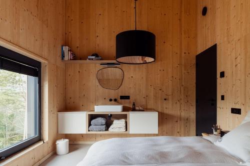 a bedroom with wooden walls and a bed and a window at Les Terrasses de Durbuy in Durbuy