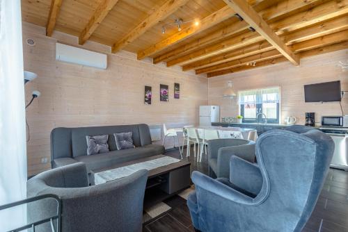 a living room with a couch and chairs and a table at Domki Kalipso in Sarbinowo
