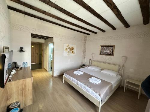 a bedroom with a bed and a television in it at Cappadocia Mihran Sultan in Avanos