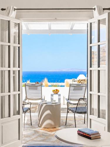 an open door to a patio with chairs and tables at San Marco Hotel and Villas in Houlakia