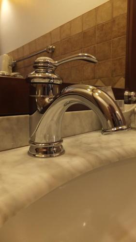 La salle de bains est pourvue d'un lavabo avec un robinet en chrome. dans l'établissement Les chambres de l'Hôte Antique, à Porto-Vecchio