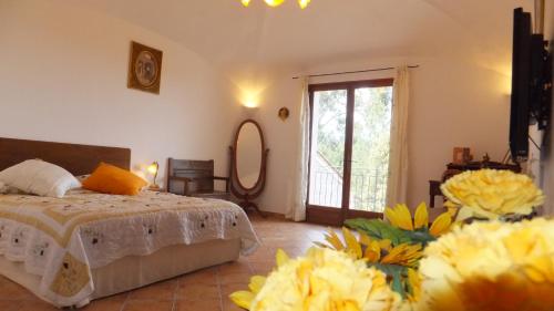 - une chambre avec un lit et des fleurs jaunes dans l'établissement Les chambres de l'Hôte Antique, à Porto-Vecchio