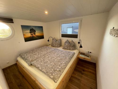 a small bedroom with a bed in a trailer at Hausboot Optima in Wangerland