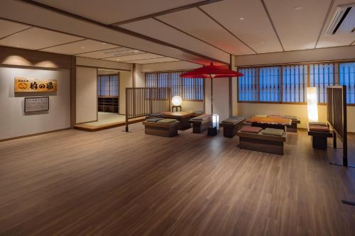 a large lobby with couches and a red umbrella at Hotel New Green Plaza in Nagaoka
