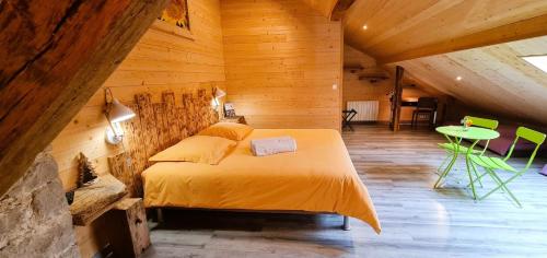 a bedroom with a bed and a table in a room at Maison D'hôtes et Spa La Boucotte in Vellerot-lès-Vercel