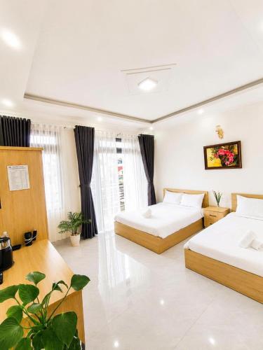 a hotel room with two beds and plants in it at Thanh Nhã House in Da Lat