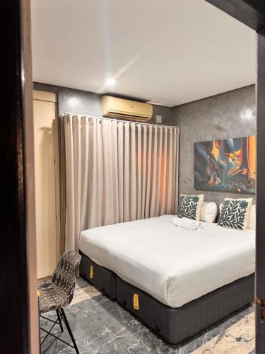 a bedroom with a large bed and a chair at Bras boutique in Steelpoort