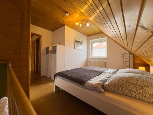 a bedroom with a large bed with a wooden ceiling at Tegeler Plate 26 in Wangerland