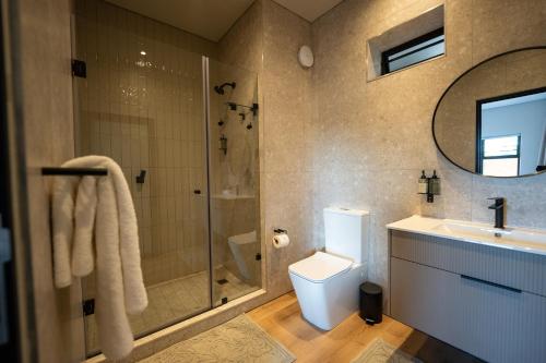 a bathroom with a shower and a toilet and a sink at The Circle Luxury Self Catering Studios in Potchefstroom