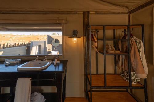 a bathroom with a sink and a mirror at Wolwedans Dune Camp in NamibRand