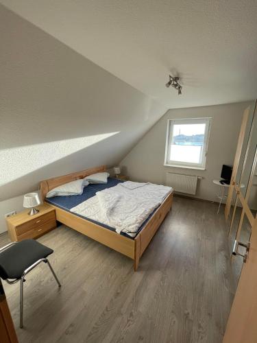 a bedroom with a bed and a desk and a window at Wangernest in Wangerland