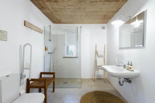 a white bathroom with a sink and a shower at Abacatus Farmhouse in Tavira
