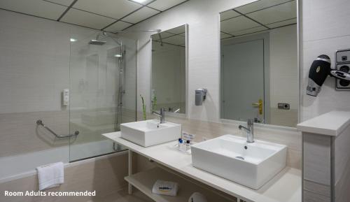 a bathroom with two sinks and a glass shower at Medplaya Hotel Flamingo Oasis in Benidorm