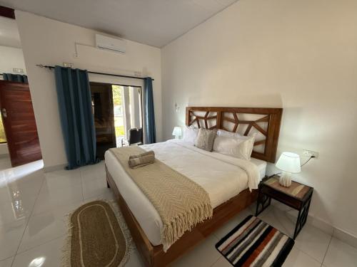 a bedroom with a large bed and a window at Tiptree Lodge in Livingstone
