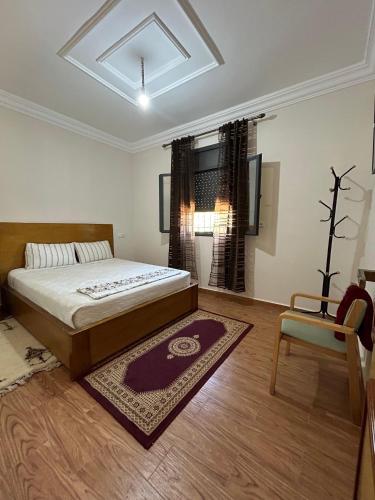 a bedroom with a large bed and a chair at DAR Assoul in Khenifra
