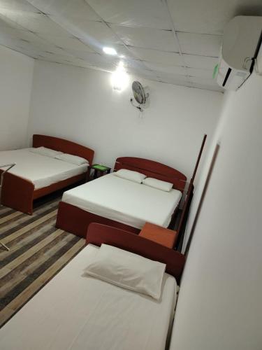 a room with two beds in a room at Sathkara Guest House in Anuradhapura