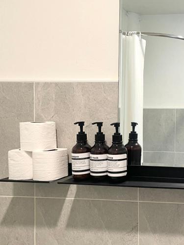 a shelf with four bottles of toilet paper and towels at Simple Cozy House Coconut Lane in Hinkong