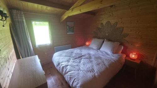 a bedroom with a bed in a wooden room at Chalet Ty Kerouannec in Guilligomarcʼh