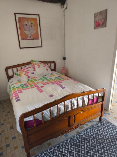 a bed with a wooden frame in a bedroom at Maisonnette de campagne in Val Couesnon