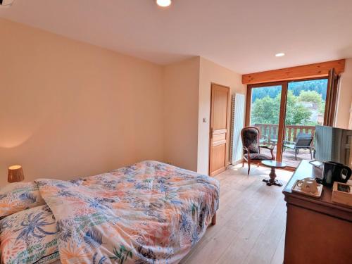 a bedroom with a bed and a television and a balcony at Chambre Jonquille in Rehaupal