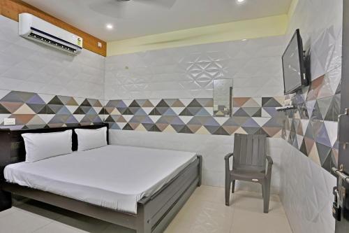 a bedroom with a bed and a chair and a tv at SAMPATH RESIDENCY in Palni