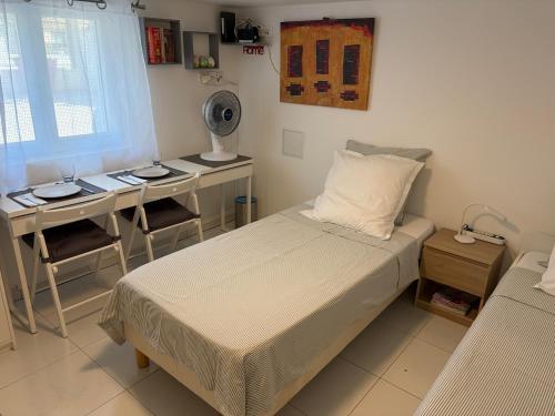 a bedroom with a bed and a table and a desk at Chez-Sonia chambre 1 in Rosny-sous-Bois