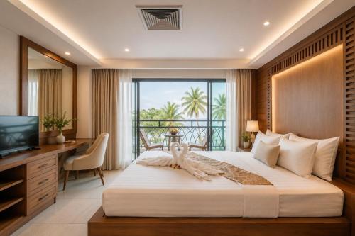 a bedroom with a bed with a desk and a window at Baywalk Residence Pattaya in Pattaya