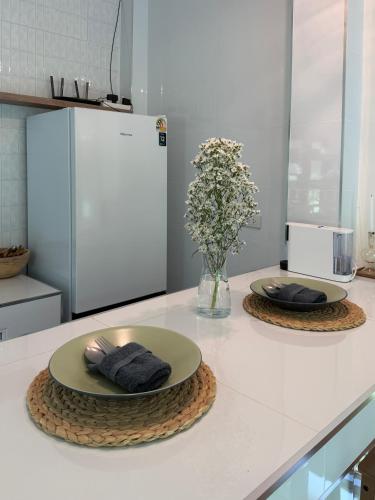 a kitchen counter with two plates and a vase of flowers at Moon & Banana in Ko Phangan