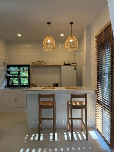a kitchen with two bar stools and two lights at Moon & Banana in Ko Phangan
