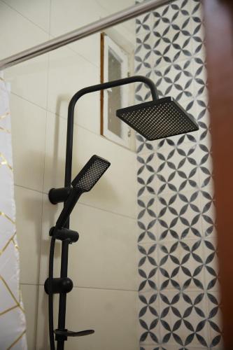 a shower head in a bathroom with a shower curtain at Dar Mhani in Salé