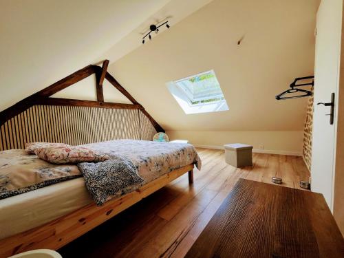 a bedroom with a bed with a wooden floor at Maison de vacances proche de Pontmain in Saint-Mars-sur-la-Futaie