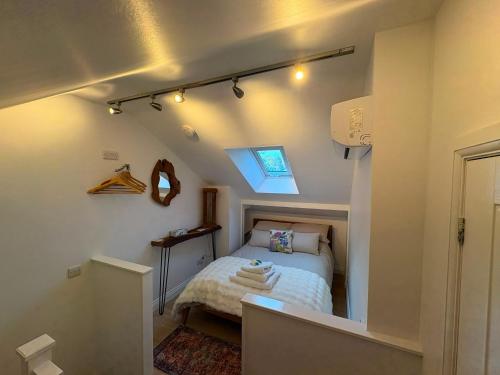 a small bedroom with a bed and a window at The Travellers Retreat in Neston