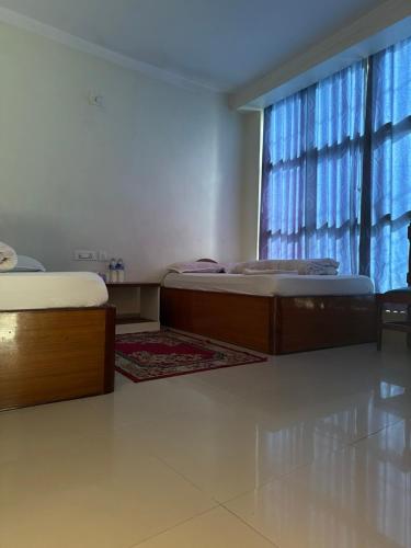 two twin beds in a room with a window at Hotel Everest in Butwāl
