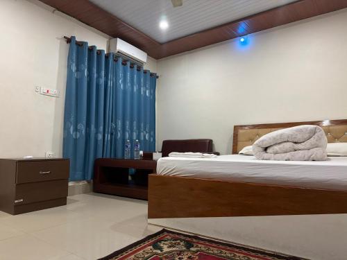 a bedroom with a bed with a blue curtain at Hotel Everest in Butwāl
