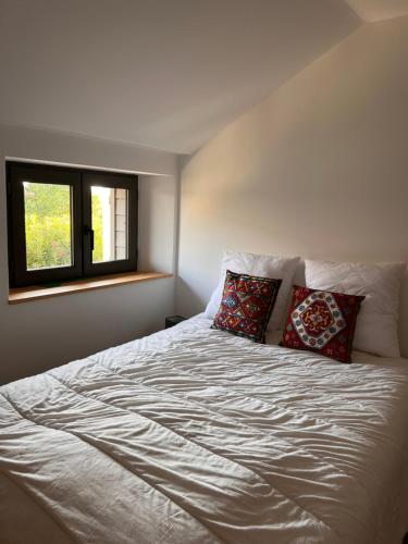 a bedroom with a white bed with two pillows at Le CRAMPOT in Lectoure