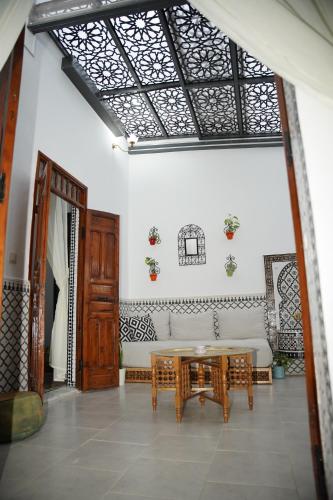 a living room with a table and a couch at Dar Mhani in Salé