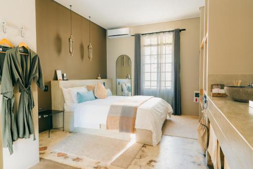 a bedroom with a white bed and a sink at Olive Grove Guesthouse in Windhoek