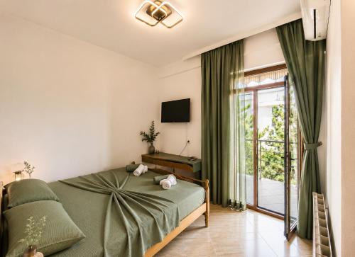 a bedroom with a bed and a sliding glass door at Bar Hotel Tirana in Kukës