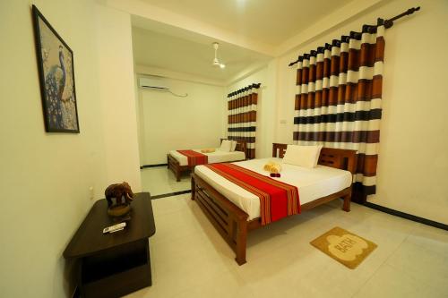 a hotel room with two beds and a table at Ocean villa in Hiriketiya