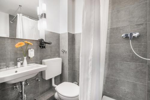 a bathroom with a toilet and a sink and a shower at Signature Hotel Astoria in Hamburg