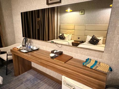 a room with two beds and a large mirror at Bloom Hotel in Baghdād