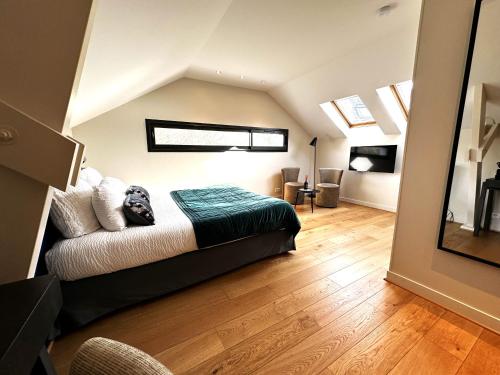 a bedroom with a bed and a couch in a room at Les Arbres Rouges in Sucé