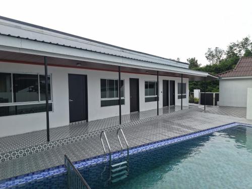 a house with a swimming pool next to a building at Chalet Gunung Stong in Dabung