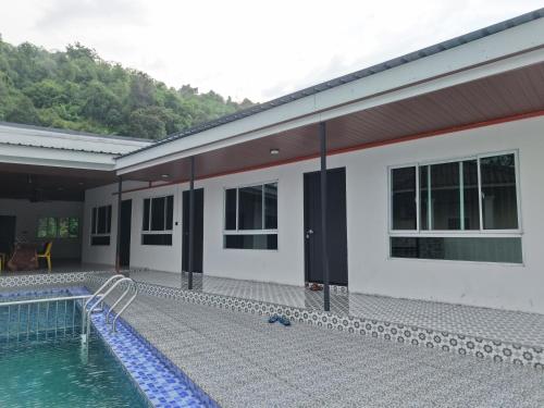 a house with a swimming pool next to a building at Chalet Gunung Stong in Dabung