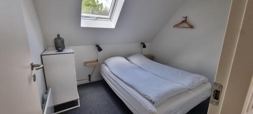 a small room with a small bed and a window at Elleholm in Odense