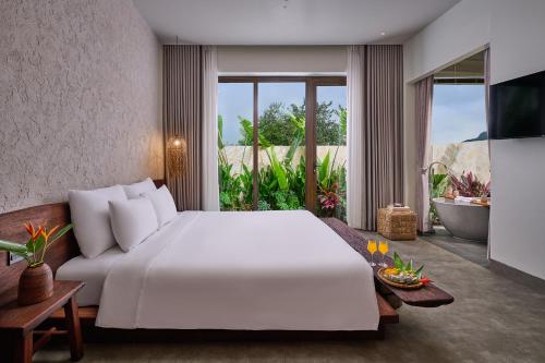 a bedroom with a large white bed and a bathroom at ArtLua Boutique Hotel Tam Coc in Văn Lâm