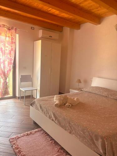 a bedroom with a bed with a stuffed animal on it at L'Incanto del mare GC in Saline Joniche