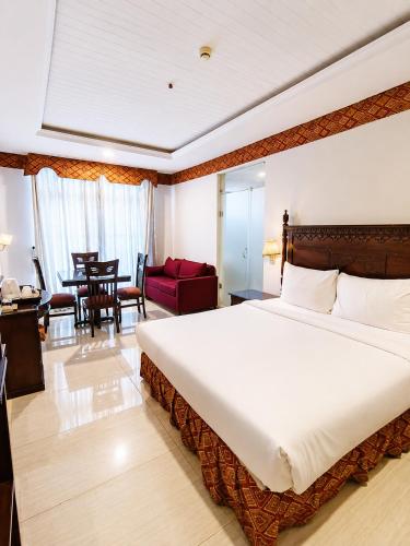 a bedroom with a large bed and a living room at Viridi Hotels Islamabad in Islamabad