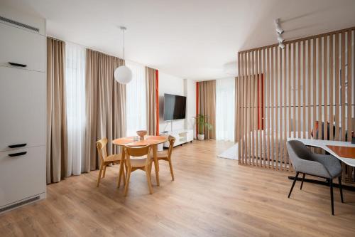 a living room with a table and chairs and a bedroom at Unique Tower Business View Apartment in Warsaw