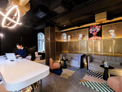 a man sitting at a table in a restaurant at TRIBE Riga City Centre - Renovated 2026 in Riga